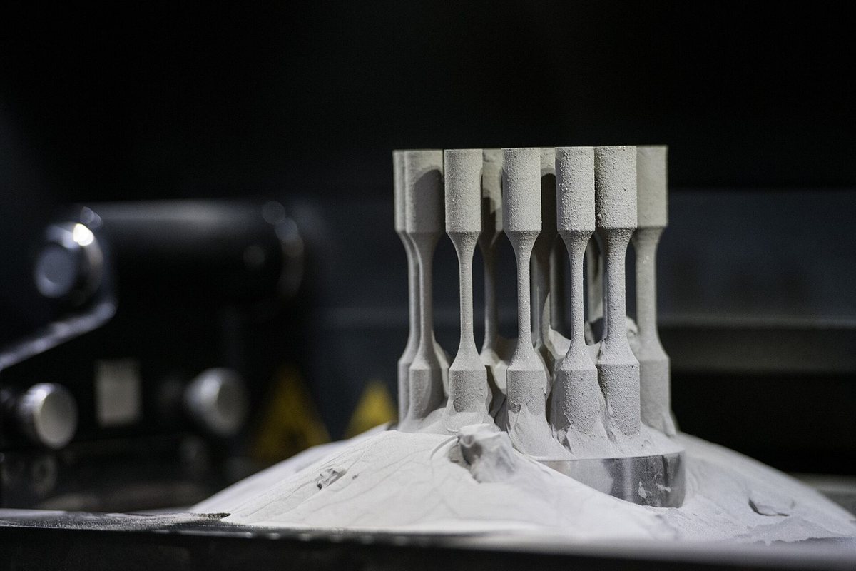 Printed metal specimens standing in the powder bed of a laser melting machine at the Institute of Physics in Prague.